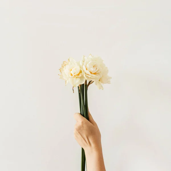 Vrouwelijke Hand Houden Narcis Bloemen Boeket Witte Achtergrond Vlakke Lay — Stockfoto