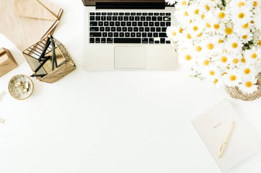 Bilgisayarlı ofis masası çalışma alanı, papatya çiçeği buketi ve beyaz arka planda not defteri. Düz konum, üst görünüm minimal serbest çalışma konsepti kopyalama alanı modeliName.