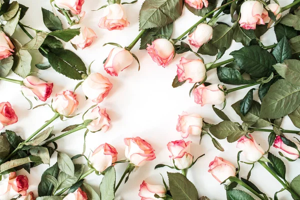 Round frame border of pink rose flowers on white background. Mockup blank copy space. Flat lay, top view floral composition.