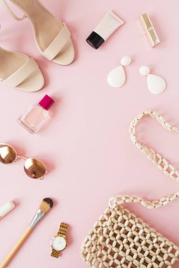 Çerçeve çerçevesi, pembe arka planda kadın aksesuarları olan yaz moda kompozisyonundan yapılmış. Düz konum, üst görünüm boş kopyalama alanı modeli.