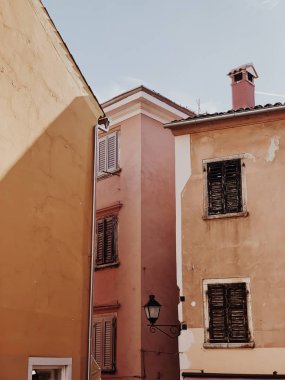 Asgari mimari konsepti. Ahşap panjurlu ve soluk renkli geleneksel Avrupa binaları. Seyahat, yaz arkaplanı.