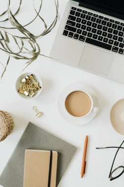 Beyaz arka planda dizüstü bilgisayarı olan ofis masası çalışma alanı. Düzlük, üst düzey kız patron iş konsepti.