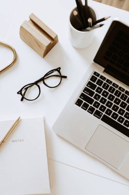 Bilgisayarlı, defterli, beyaz masadaki gözlüklü ofis masası çalışma alanı. Düz yatış, üst görünüm minimum kadın, kız patron geçmişi..