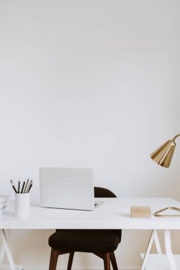 Modern iç tasarım konsepti. Parlak İskandinav ofis masa çalışma alanı dizüstü bilgisayarı, lambası, kitapları.