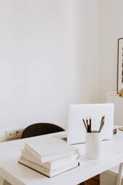 Modern iç tasarım konsepti. Parlak İskandinav ofis masası çalışma alanı, dizüstü bilgisayarlar, kitaplar. Çalışma kabinesi.