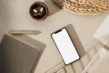 Boş ekran akıllı telefon, bej arka planda kırtasiye malzemesi. Düz yerde, üst tarafta. Stili ev ofis masası çalışma alanı. İş, çalışma şablonu.