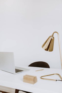 Modern iç tasarım konsepti. Parlak İskandinav ofis masası çalışma alanı dizüstü bilgisayarı, lambası var. Çalışma dolabı. Kız patron stüdyo konsepti.