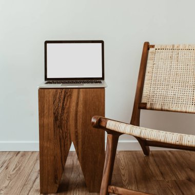 Boş maket uzay ekranlı dizüstü bilgisayar. Asgari ofis çalışma alanı. İş, iş geçmişi. Rattan ahşap koltuklu modern iç tasarım konsepti.