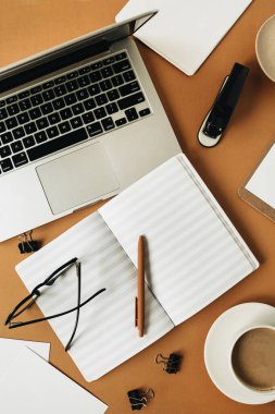 İç ofis masası çalışma alanı, dizüstü bilgisayarı ve kızıl arka planı var. Düzlük, üst düzey kız patron iş konsepti.