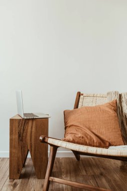 Bilgisayarlı ofis çalışma alanı. Modern iç tasarım konsepti. Şık bir ahşap sandalye, ekose örgü, zencefil yastık..
