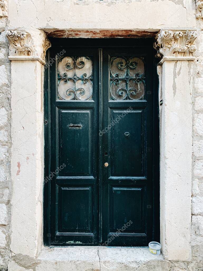 Dubrovnik, Croatia, 2019. An old vintage green wooden door. Traditional European architecture. Travel concept.