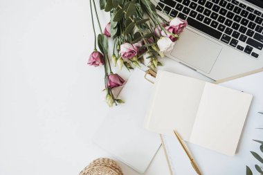 Düz yatış, üst kattaki ofis çalışma alanı boş kağıt kağıtlar ve beyaz masada dizüstü bilgisayarla. Model kopyalama alanı ile ev kavramında çalış