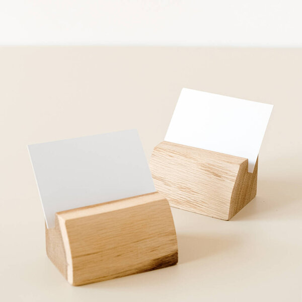 Пустая бумажная карточка с макетом места для копирования в держателях карточек на бежевом фоне. Минимальный шаблон бизнес-бренда.