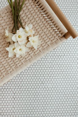 Narcissus çiçekleri mozaik fayans üzerinde rattan bankta