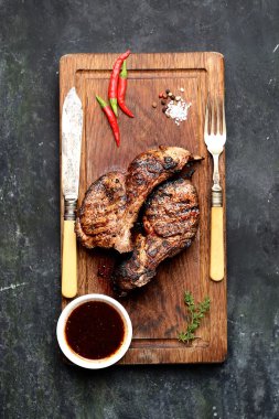 Grilled lamb steaks on cutting board