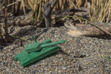 Savaş alanında plastik oyuncak savaş tankı, plastik oyuncak, küçük oyuncak, izm