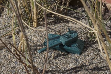 Savaş alanında plastik oyuncak savaş tankı, plastik oyuncak, küçük oyuncak, izm