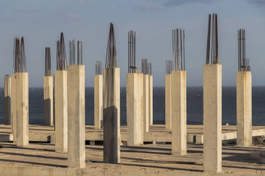 Arka planda deniz olan beton sütunlar