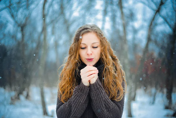 Europäisches junges Mädchen mit roten Haaren und blauen Augen auf die Natur in einem Park im Schnee bei den Winterspaziergängen — Stockfoto