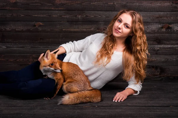 Una giovane bella ragazza che tiene in braccio un animale selvatico di volpe traumatizzato da un uomo e salvato da lei e ora vive come prima — Foto Stock