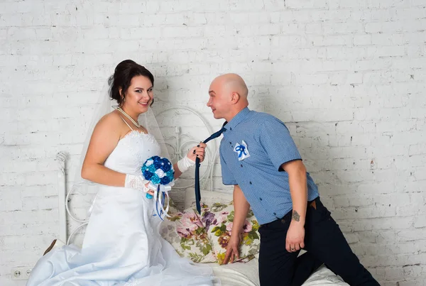 Casamento jovem casal e jogar um vestido de noiva uns aos outros bandas de casamento e muito feliz — Fotografia de Stock