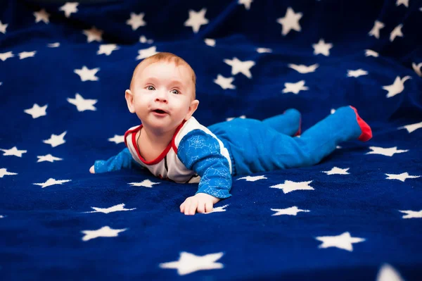 Criança 6 meses de idade e sorrindo em casa em um cobertor azul do céu estrelado — Fotografia de Stock