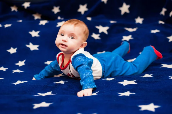 Criança 6 meses de idade e sorrindo em casa em um cobertor azul do céu estrelado — Fotografia de Stock