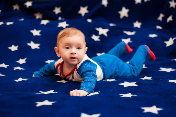 Criança 6 meses de idade e sorrindo em casa em um cobertor azul do céu estrelado — Fotografia de Stock