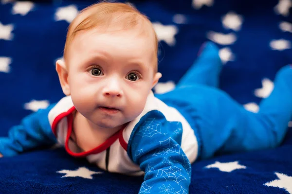 Criança 6 meses de idade e sorrindo em casa em um cobertor azul do céu estrelado — Fotografia de Stock