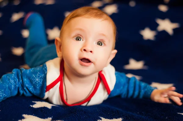 Criança 6 meses de idade e sorrindo em casa em um cobertor azul do céu estrelado — Fotografia de Stock