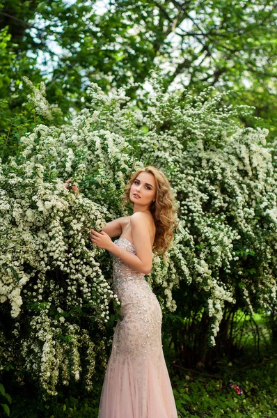Esti koktél ruha a tavasz közepén között virágzó bokrok és fák gyönyörű, mosolygós lány — Stock Fotó