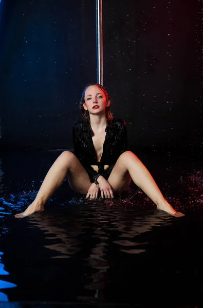 Una joven y hermosa mujer europea en un estudio fotográfico con agua se dedica a bailar a medias con bóvedas de poste — Foto de Stock