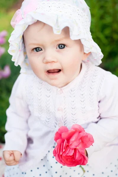 老欧洲乌克兰小宝贝在花园举行散步一朵花和草莓在她手中的 8 个月的女孩 — 图库照片