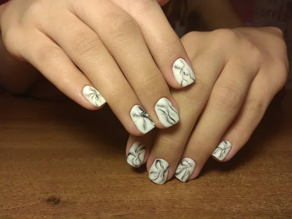 The manicurist excellently made her work a beautiful manicure with a polish gel on her hands and the client is happy — Stock Photo, Image