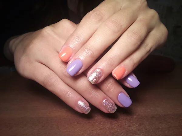 The manicurist excellently made her work a beautiful manicure with a polish gel on her hands and the client is happy