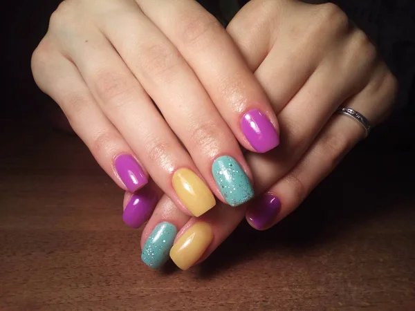 The manicurist excellently made her work a beautiful manicure with a polish gel on her hands and the client is happyThe manicurist excellently made her work a beautiful manicure with a polish gel on her hands and the client is happyThe manicurist exc — 图库照片