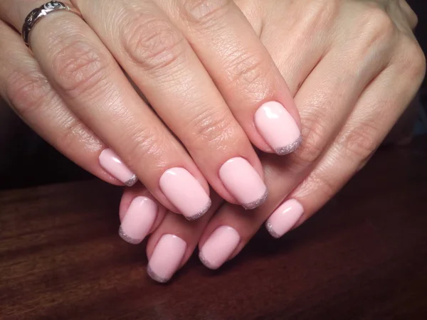 The manicurist excellently made her work a beautiful manicure with a polish gel on her hands and the client is happyThe manicurist excellently made her work a beautiful manicure with a polish gel on her hands and the client is happyThe manicurist exc — Stock Photo, Image