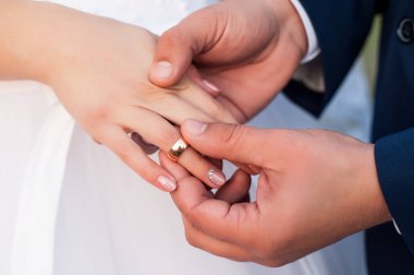 Düğün gününde, koca geline beyaz elbiseli bir alyans takar ve iki âşığın kalpleri bir aile içinde birleşince mutlu olur.