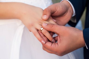 Düğün gününde, koca geline beyaz elbiseli bir alyans takar ve iki âşığın kalpleri bir aile içinde birleşince mutlu olur.