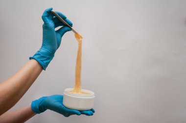 Güzellik uzmanı, bir kadının güzelliği için beyaz gri bir arkaplan üzerine yaptığı çalışmalar için iş aletini sunar.