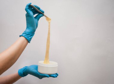 Güzellik uzmanı, bir kadının güzelliği için beyaz gri bir arkaplan üzerine yaptığı çalışmalar için iş aletini sunar.