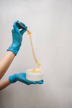 Güzellik uzmanı, bir kadının güzelliği için beyaz gri bir arkaplan üzerine yaptığı çalışmalar için iş aletini sunar.