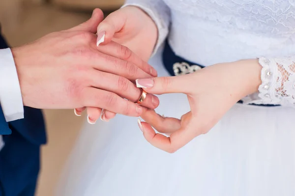 on the wedding day, the husband puts on a wedding ring to the bride in a white dress and it is happiness when two lovers\' hearts are united in a family