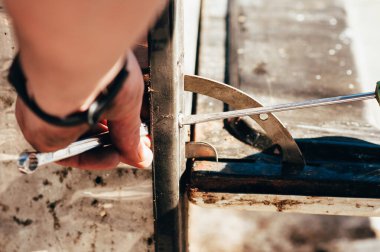 Adam metal ve aletlerle çalışıyor.