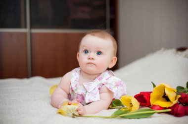 Küçük kız 6 aylık, büyük mavi gözlü, mutlu.