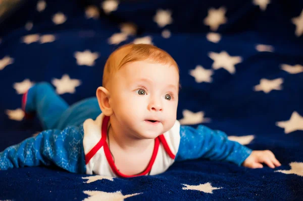 Liten Pojke Ligger Blå Bakgrund Med Stjärnor — Stockfoto