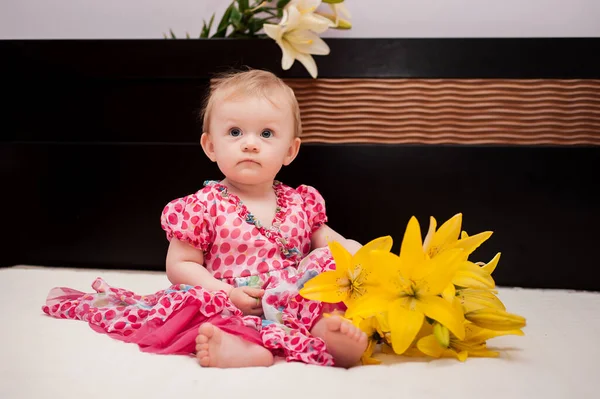Aylık Küçük Bir Kız Sarı Çiçekli Bir Yatakta — Stok fotoğraf