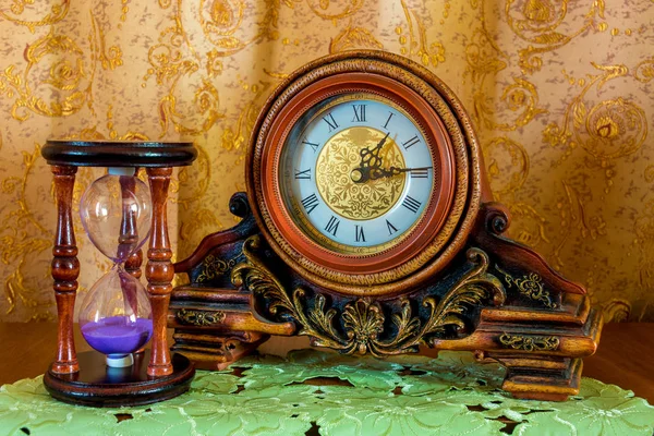 Zdjęcie starego zegara i sandglass na brązowym tle — Zdjęcie stockowe