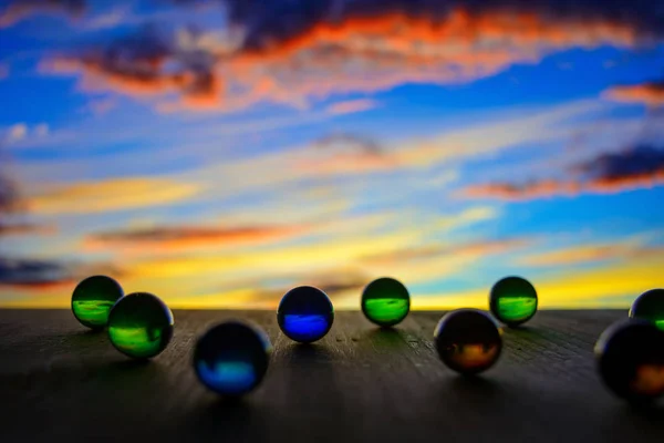 Photo of many glass balls on wooden board on blurred background — Stock Photo, Image