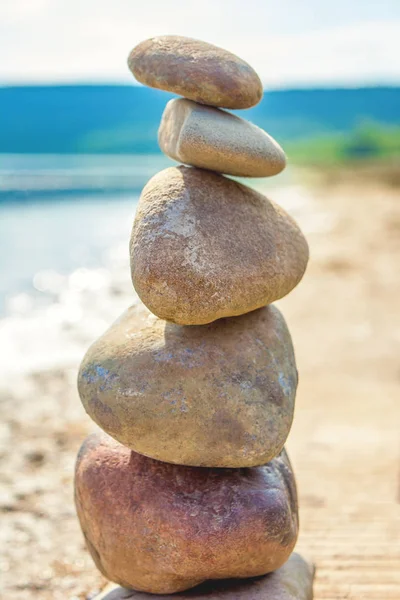 Photo of five stones balanced on top of eachother on a beach — Stock Photo, Image